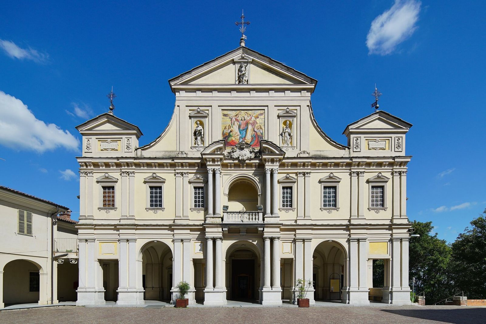 La facciata del santuario di Santa Maria Assunta al Sacro Monte di Crea, con il mosaico dell'Assunta, sotto un cielo blu