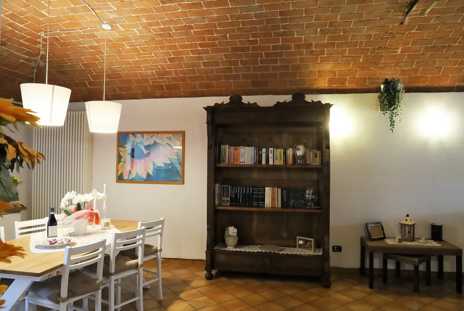 La zona pranzo dell'Appartamento Viola con la libreria antica